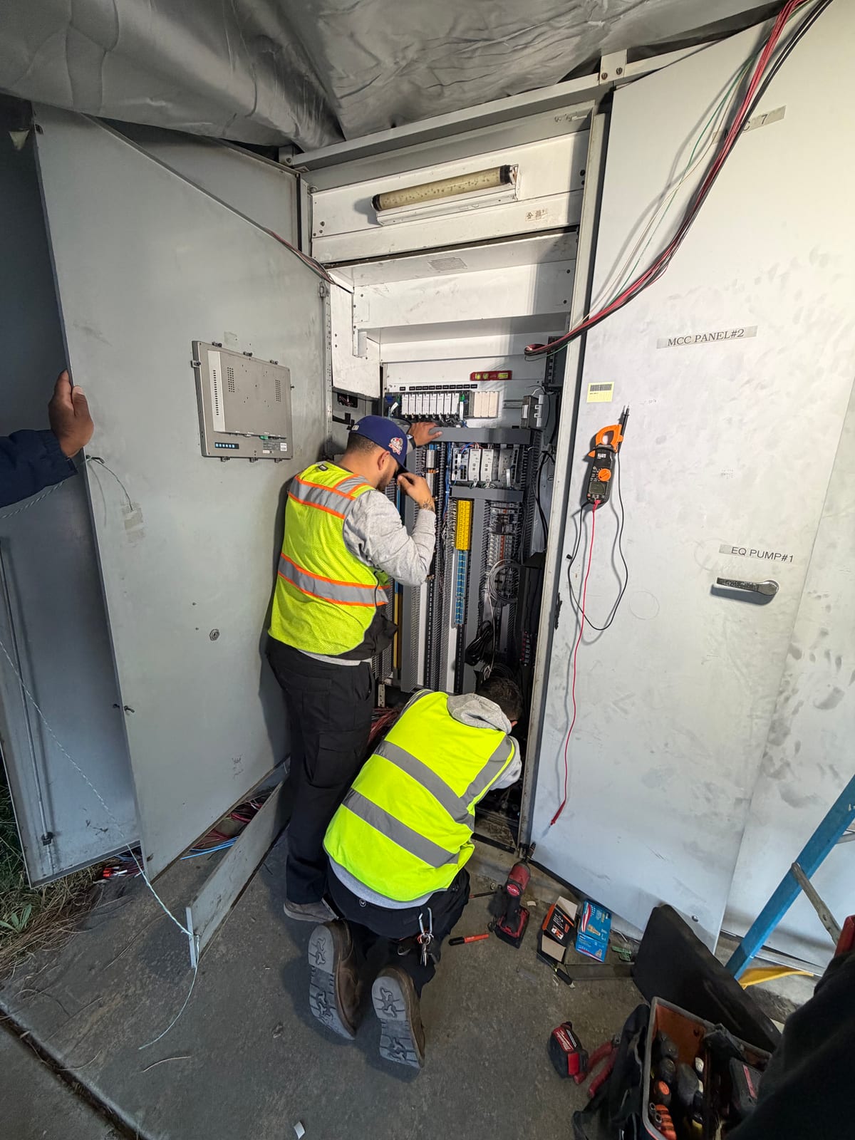 Two-person crew installing large industrial panel